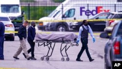 A body is taken from the scene where multiple people were shot at a FedEx Ground facility in Indianapolis, April 16, 2021. 