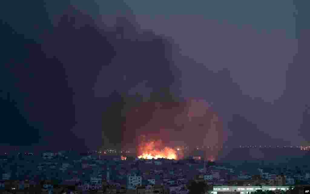 Smoke rises in the air and flames spread across buildings after Israeli strikes in the Shijaiyah neighborhood, in Gaza City, July 20, 2014.
