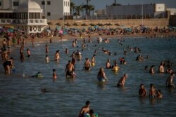 FILE - Bathers enjoy the beach in Cadiz, Spain, July 24, 2020. With the coronavirus rebounding in parts of Spain, it appears that several regions have not adequately prepared to trace new infections.