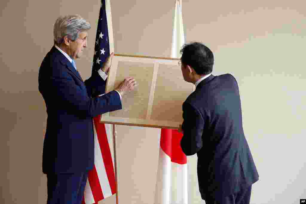 U.S. Secretary of State John Kerry, left, points out to Japan&#39;s Foreign Minister Fumio Kishida a passage about friendship in a replica of a letter on a small diplomatic matter from former U.S. President Abraham Lincoln to the Tycoon of Japan in 1861, before their bilateral meeting in Hiroshima, Japan, April 11, 2016.