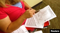 Pasien bedah bariatrik, Carolyn Dawson, sedang melihat diagram pembedahan di ruang kantor dokter bedah Dr. Michael Snyder di Denver, lima hari sebelum menjalani pembedahan, 25 Agustus 2010.