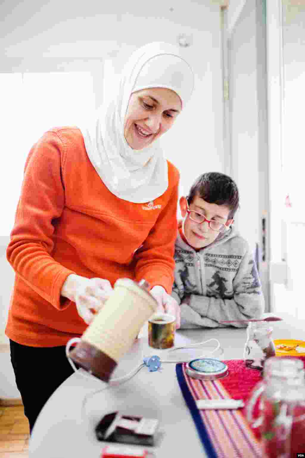 Noor Wadkhuka, with her 10-year old son Gyakhra, pours tea for visitors. (V. Undritz for VOA)