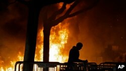 FILE - In this Feb. 1, 2017, photo, a fire set by demonstrators protesting a scheduled speaking appearance by Breitbart News editor Milo Yiannopoulos burns on Sproul Plaza on the University of California, Berkeley campus.