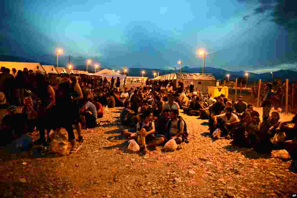 In the southern Macedonian town of Gevgelija, migrants sit on the ground at a refugee camp, Sept. 8, 2015. Hundred of thousands migrants and refugees trying to reach the heart of Europe via Turkey, Greece, the Balkans and Hungary have faced dangers, difficulties and delays on every link of the journey.
