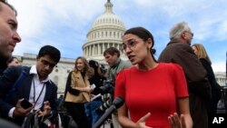 FILE - Rep.-elect Alexandria Ocasio-Cortez, D-N.Y., talks with reporters, Nov. 14, 2018, following a photo opportunity on Capitol Hill in Washington, with the freshman class.