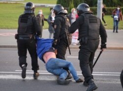 Riot police detain a demonstrator during an opposition rally to protest the presidential inauguration of Alexander Lukashenko, in Minsk, Belarus, Sept. 23, 2020.