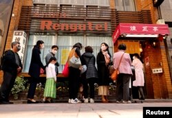 People form a line as they try to have lunch at Rengatei restaurant in Tokyo