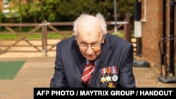 Veteran Perang Dunia II (WWII) Kapten Tom Moore (99 tahun), berjalan di kebunnya di Marston Moretaine, utara London, untuk menggalang dana bagi Badan Kesehatan Nasional Inggris, Kamis (16/4).