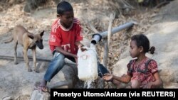 Anak-anak mengisi jerigen di sumber air di Desa Sanleo, Kabupaten Malaka, Nusa Tenggara Timur, 10 Oktober 2015. (Foto: Prasetyo Utomo/Antara via Reuters)