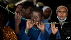 Sub-Saharan migrants wait their turn to leave the Golfo Azzurro rescue vessel after arriving at the port of Pozzallo, south of Sicily, Italy, with more than 220 migrants aboard, rescued by members of Proactive Open Arms NGO, Feb. 5, 2017.