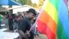 FILE - Samba Chesterfield, Director of Gays and Lesbians Association of Zimbabwe, prepares to hoist their official flag alongside the Zimbabwean flag during an event in Harare, Zimbabwe, May, 19, 2012. 