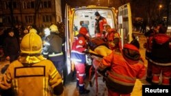 ພວກນາຍແພດສຸກເສີນ ຫາມພົນລະເມືອງທີ່ໄດ້ຮັບບາດເຈັບຂຶ້ນລົດສຸກເສີນ ຢູ່ຕຶກບ້ານພັກ ຫຼື ອາພາດເມັນ ທີ່ໄດ້ຮັບຄວາມເສຍຫາຍໃນລະຫວ່າງການໂຈມຕີດ້ວຍລູກສອນໄຟຂອງຣັດເຊຍ, ທ່າມກາງການໂຈມຕໍ່ຢູເຄຣນຂອງຣັດເຊຍ, ໃນນະຄອນຫຼວງກີຢິບ ຂອງຢູເຄຣນ, ວັນທີ 13 ທັນວາ 2023.