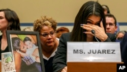 FILE - Yazmin Juárez reacts as a photos of her daughter, Mariee, 1, who died after her released from detention by US Immigration and Customs Enforcement, is placed nearby at a House Oversight subcommittee hearing, Capitol Hill, Washington, July 10, 2019.