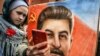 RUSSIA -- A woman, next to a girl, holds a portrait of Soviet leader Josef Stalin and takes a selfie at his grave outside the Kremlin on the Red Square in Moscow, March 5, 2019