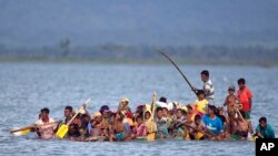Waislam wa Rohingya wakisafiri kwenye mashua iliyotengenezwa kwa plastiki kuvuka mto Naf kuelekea Bangladesh wakikimbia mauaji Jumapili Novemba 12, 2017.