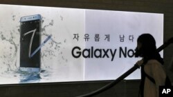 A visitor passes by an advertisement of the Samsung Electronics Galaxy Note 7 smartphone at its shop in Seoul, South Korea, Oct. 11, 2016. 