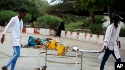 FILE - Medical workers help a civilian on stretcher who was wounded in a suicide bomb attack, at Madina hospital in Mogadishu, Somalia, July 24, 2019. 