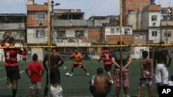 Warga bermain sepak bola di Nova Holanda, kawasan kumuh di Mare, Rio de Janeiro, Brazil, Minggu 30 Maret 2014.