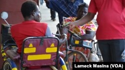 Conforzi Biliati recieves money from an alms giver in the street of Blantyre. Government says it wants to ban street begging.