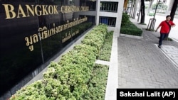 A Thai man walks past the sign of Bangkok Christian College in Bangkok, Thailand, Thailand's oldest private school established by American Presbyterian missionaries in 1852.
