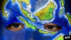 អ្នក​សម្តែង​មួយ​រូប​បង្ហាញ​ខ្លួន​នៅ​​មុខ​បដា​នៅ​អាកាសយានដ្ឋាន Kuala Lumpur ​ដែល​មាន​សរសេរ​សារ​ចែក​រំលែក​ទុក្ខ​និង​បួងសួង​ដល់​អ្នក​ដំណើរ​លើ​យន្តហោះ​ MH370 ដែល​បាត់​ដាន