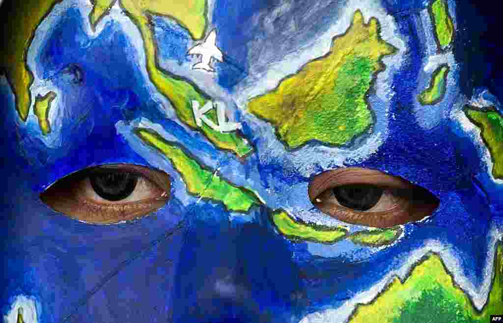 Seorang warga di Kuala Lumpur, Malaysia mengecat wajahnya sebagai solidaritas terhadap para penumpang Malaysia Airlines (MH370) yang belum diketahui nasibnya setelah lebih dari seminggu hilang.&nbsp;