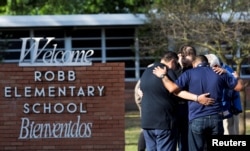 Warga berkumpul di SD Robb, lokasi penembakan massal di Uvalde, Texas, AS, 25 Mei 2022. (Foto: REUTERS/Nuri Vallbona)