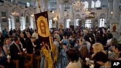 Foto yang diambil pada Minggu 15 April 2012, pemeluk Kristen Ortodoks Suriah menghadiri misa Paskah di Damaskus, Suriah. Umat Kristen yang berjumlah 10 persen dari populasi Suriah yang berjumlah lebih dari 22 juta, mengatakan mereka rentan terhadap kekerasan yang melanda negara terse but sejak Maret 2011. Mereka takut Suriah akan menjadi seperti Irak, di mana umat Kristen terjebak dalam peperangan antara kelompok-kelompok Islam. (AP Photo/Bassem Tellawi, File)