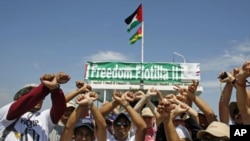 Activists gesture in front of the Stefano Chiarini ship during a protest against the banning of a pro-Palestinian flotilla to depart from Greece, on the Greek island of Corfu, July 5, 2011