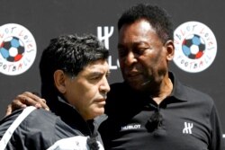 FILE - Football legends Pele, right, and Diego Maradona attend an advertising soccer event on the eve of the opening of the UEFA 2016 European Championship in Paris, France, June 9, 2016.