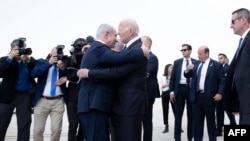 Perdana Menteri Israel Benjamin Netanyahu (kiri) menyambut Presiden AS Joe Biden yang baru mendarat di Bandara Ben Gurion di Tel Aviv, 18 Oktober 2023, di tengah perang antara Israel dan Hamas. (Foto: Brendan Smialowski/AFP)