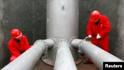 FILE - Laborers work at a PetroChina refinery in Suining, southwest China's Sichuan province.