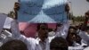 A man holds a banner calling for people who killed protesters to be punished, during a march by members of the Sudanese medical profession syndicate, at the sit-in inside the Armed Forces Square, in Khartoum, April 17, 2019. 