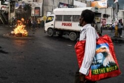 A man walks pass burning tires during a protest against fuel shortages and to demand the resignation of President Jovenel Moise, in Port-au-Prince, Haiti, on September 20, 2019.