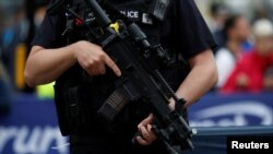 Armed police officers keep watch over junior runners competing in the Great Manchester Run in central Manchester, Britain, May 28, 2017. 