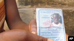 A mother shows the identification of her son who was killed in one of the many recent pro-democracy protests in Guinea.