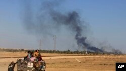 Asap terlihat di sementara orang meninggalkan rumahnya saat bentrokan antara pasukan keamanan Irak dan anggota ISIS di Irak. (Foto: dok.)