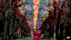 2016年2月2日孩子滑板车的女孩在北京张灯结彩准备迎接中国农历新年的庙会所在地地坛公园玩耍。