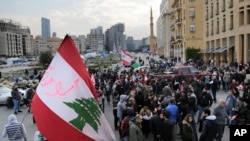 Anti-government protesters block a road that links to Martyrs square, where they set their protest encampment, after it was opened by the security forces in the morning, in downtown Beirut, Jan. 28, 2020.