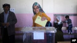 ស្រ្តី​ម្នាក់​កំពុង​បោះ​ឆ្នោត​នៅ​ក្នុង​ស្ថានីយ​បោះឆ្នោត​ទីក្រុង Diyarbakir ភាគអាគ្នេយ៍​ប្រទេស​តួកគី​កាល​ពី​ថ្ងៃទី​១៦ មេសា ២០១៧។