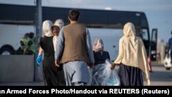 FILE - Afghan refugees who supported Canada’s mission in Afghanistan prepare to board buses after arriving in Canada, at Toronto Pearson International Airport, Aug. 24, 2021. (MCpl Genevieve Lapointe/Canadian Forces Combat Camera)