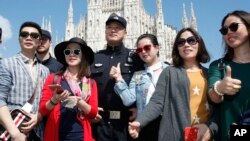 2016年5月3日在意大利开始为期两周试验巡逻的中国警察与在米兰大教堂广场的中国游客合影。
