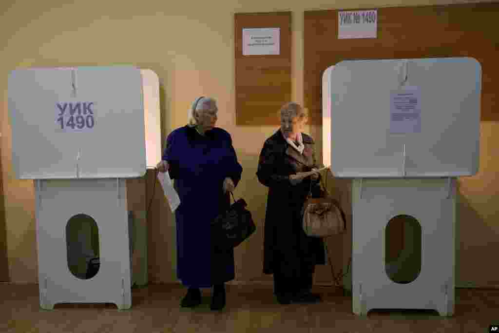 Two elderly women look at each other at a polling station in Moscow's mayoral election, Sept. 8, 2013.