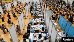 People receive the first dose of the AstraZeneca COVID-19 vaccine as Thailand starts a mass inoculation, at a gymnasium inside the Thammasat University in Pathum Thani, Thailand, June 7, 2021. 