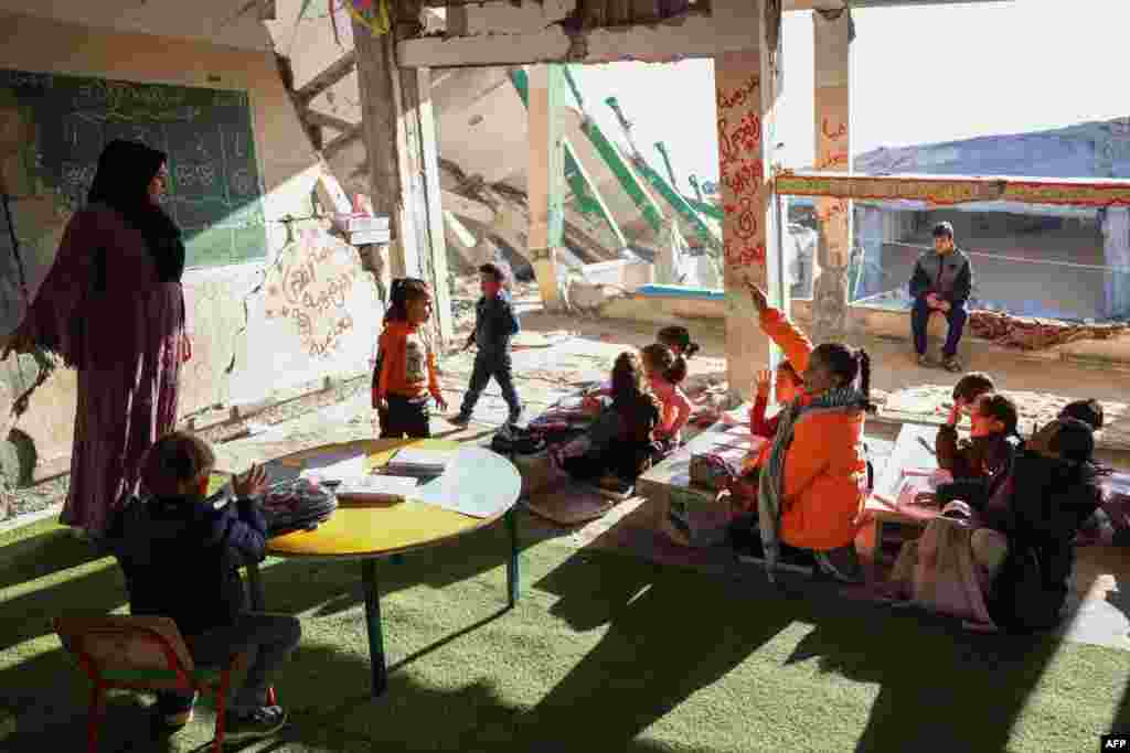 Palestinian teacher Doha al-Attar, 30, a mother of four from Rafah, runs a class for children in a heavily damaged classroom in Khan Yunis where she was displaced.
