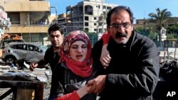 레바논 베이루트의 쿠웨이트 문화원 인근에서 19일 폭탄 테러가 발생한 가운데 한 남성이 다친 여성을 돕고 있다.