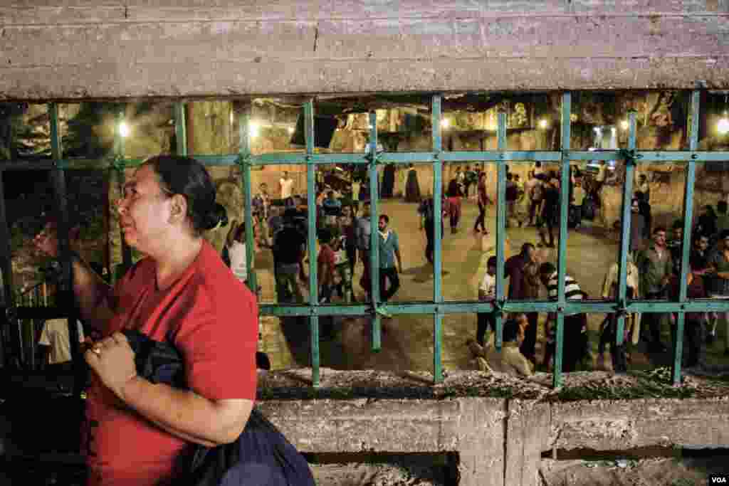 A coptic woman cries while she praying at the cave where the holy family is believed to have lived in Assiut, Egypt, August 20, 2017. (H. Elrasam/VOA)