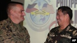 Direktur Pelatihan Program Balikatan 2012 Amerika, Brigjen Marinir Frederick Padilla (kiri) berjabat tangan dengan Pimpinan Militer Filipina, Jendral Jesse Dellosa dalam pembukaan latihan bersama tahunan di Camp Aguinaldo, Filipina (16/4).