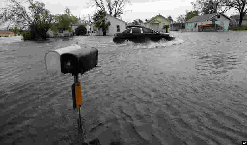 A driver moves through flood waters left behind by Hurricane Harvey, in Aransas Pass, Texas, Aug. 26, 2017.