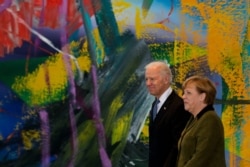 FILE - German Chancellor Angela Merkel, right, walks with then-U.S. Vice President Joe Biden for a meeting at the chancellery in Berlin, Germany, Feb. 1, 2013.